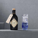 Illusionist Dry Gin Bottle and Blue Gin Cocktail in a Glass